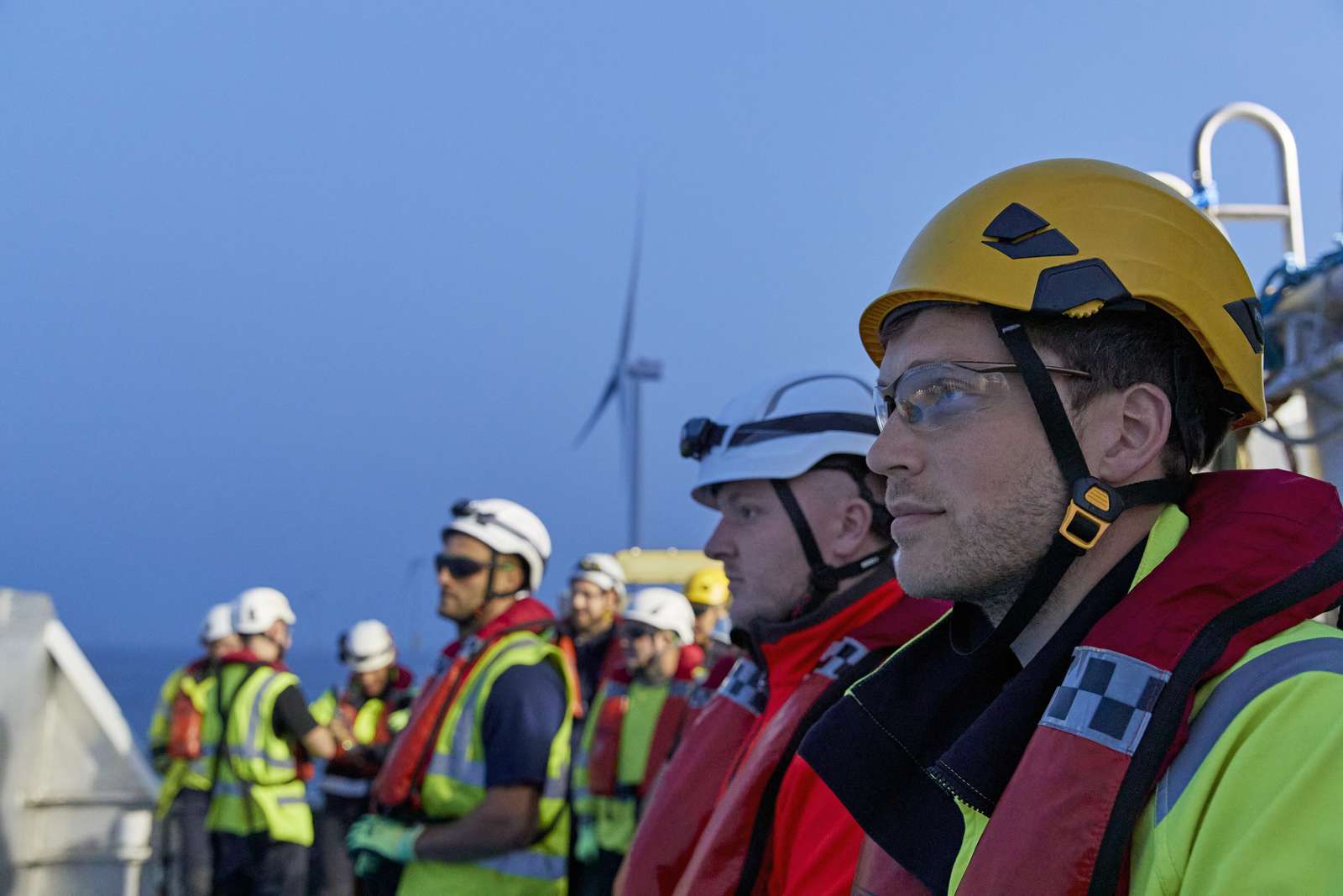 Workers looking out over an offshore windfarm