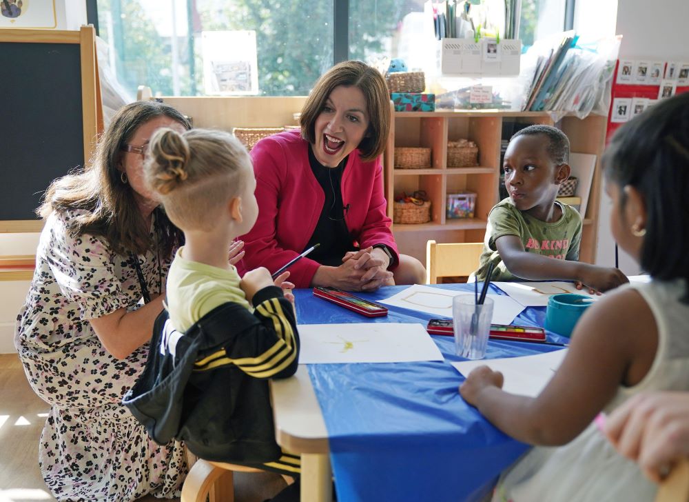 Phillipson sits at table with young people